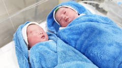 刚出生的双胞胎婴儿，一个不肯睁眼，一个不肯